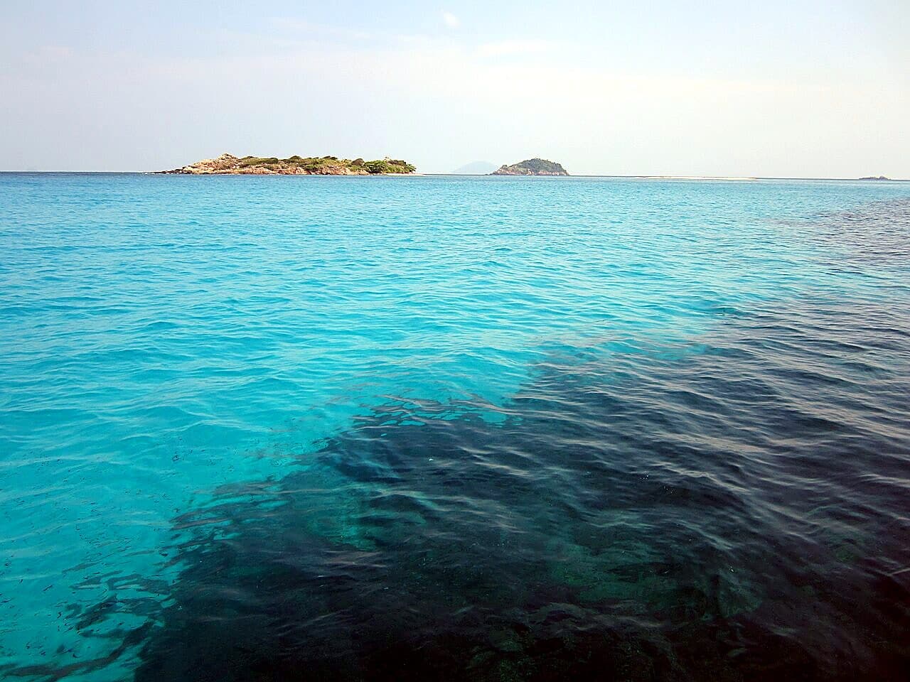 Clear turquoise water off Pulau Redang, with small marine-park islets on the horizon